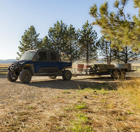 A 2027 Polaris RANGER CREW XD 1500 NorthStar Extreme Duty UTV pulling a heavy trailer.