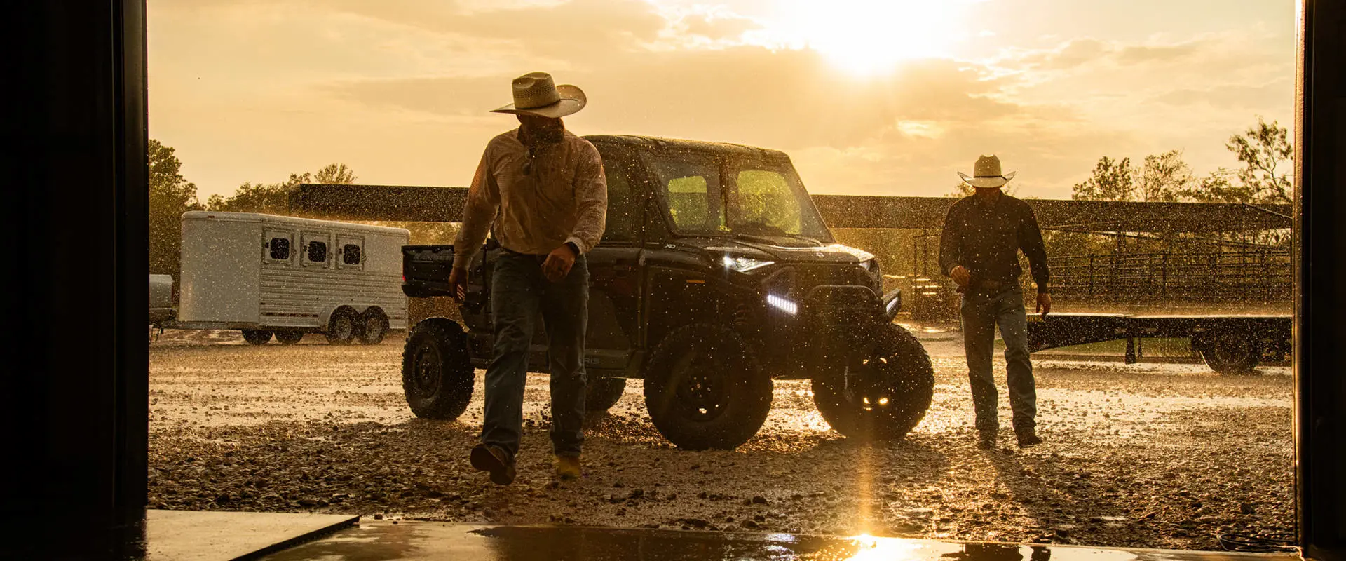 Dos agricultores bajo la lluvia mientras se alejan de un UTV Polaris RANGER CREW XD 1500 NorthStar Texas Edition 2027 para uso extremo.
