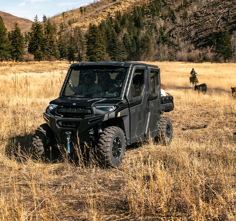 4 people sitting in the factory installed cab of a 2027 Polaris RANGER CREW XP 1000 NorthStar Texas Edition UTV.