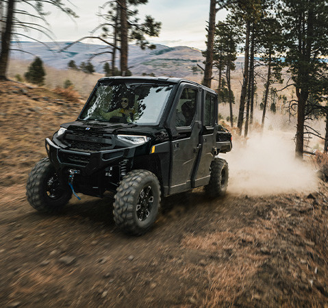 4 people enjoying the factory installed air conditioning in a 2027 Polaris RANGER CREW XP 1000 NorthStar Texas Edition UTV while trail riding.