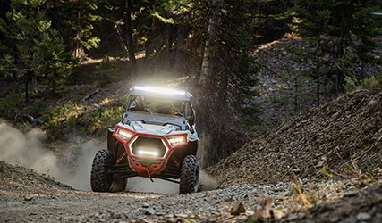 Front view of a RZR Trail S with the lights on