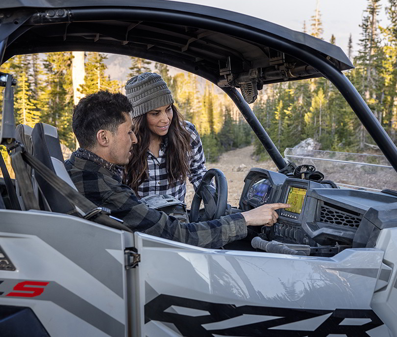 Polaris RZR Trail racing on a trail road in the sunset