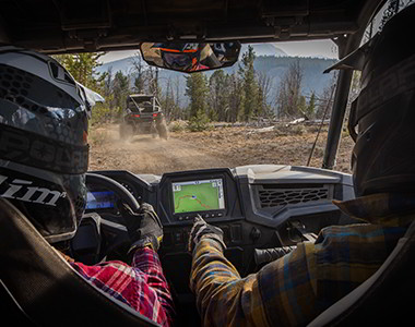 Polaris RZR Trail racing on a trail road in the sunset