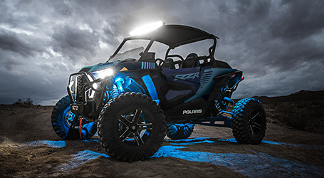 RZR with all its lights on parked under a thunderstorm