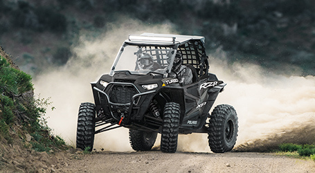 Front shot of a rzr drifting on a trail