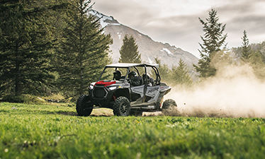 RZR XP 4 Turbo racing through a green field