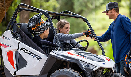 Girl smiling after driving her Polaris RZR 200