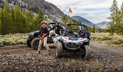 Family of Polaris RZR drivers parking after a trail ride
