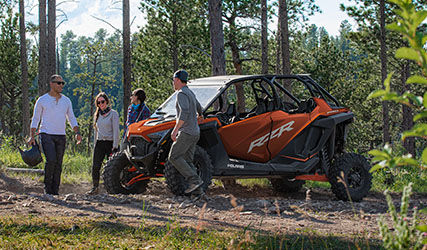Amigos y un RZR Pro XP 4 en un bosque