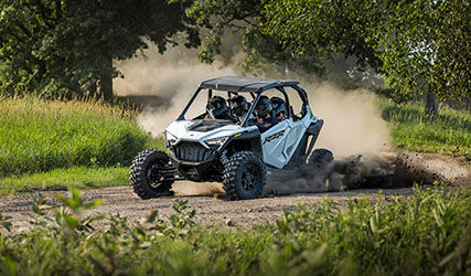 polaris rzr pro xp 4 blanco que corre en una curva polvorienta