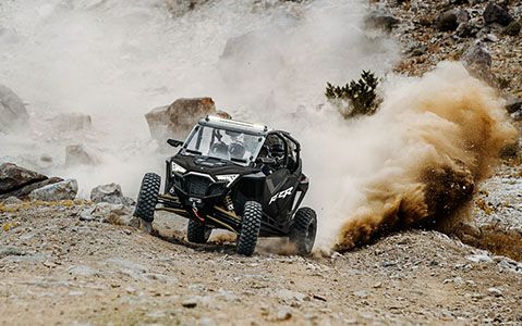 RZR Pro XP 4 and drivers in a rocky green trail