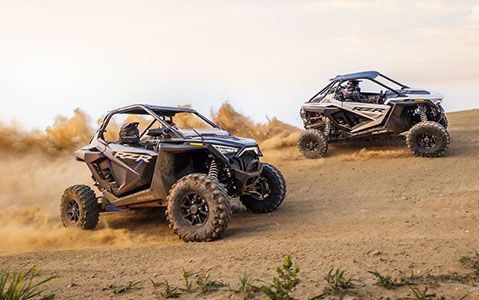 Dos RZR Pro XP se desempeñan en una colina arenosa