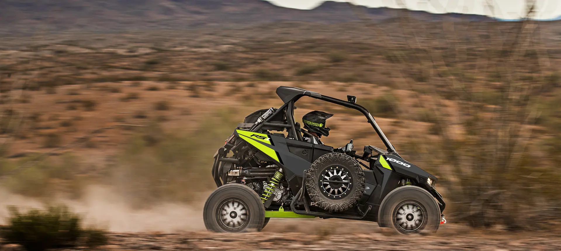 Polaris RZR RS1 racing down a trail with a spare tire