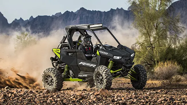 RZR RS1 racking down a trail on rocky terrain