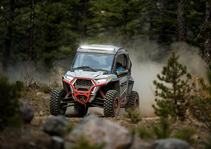 Polaris RZR Trail S speeding down a trail with accessories from the adventurer collection installed