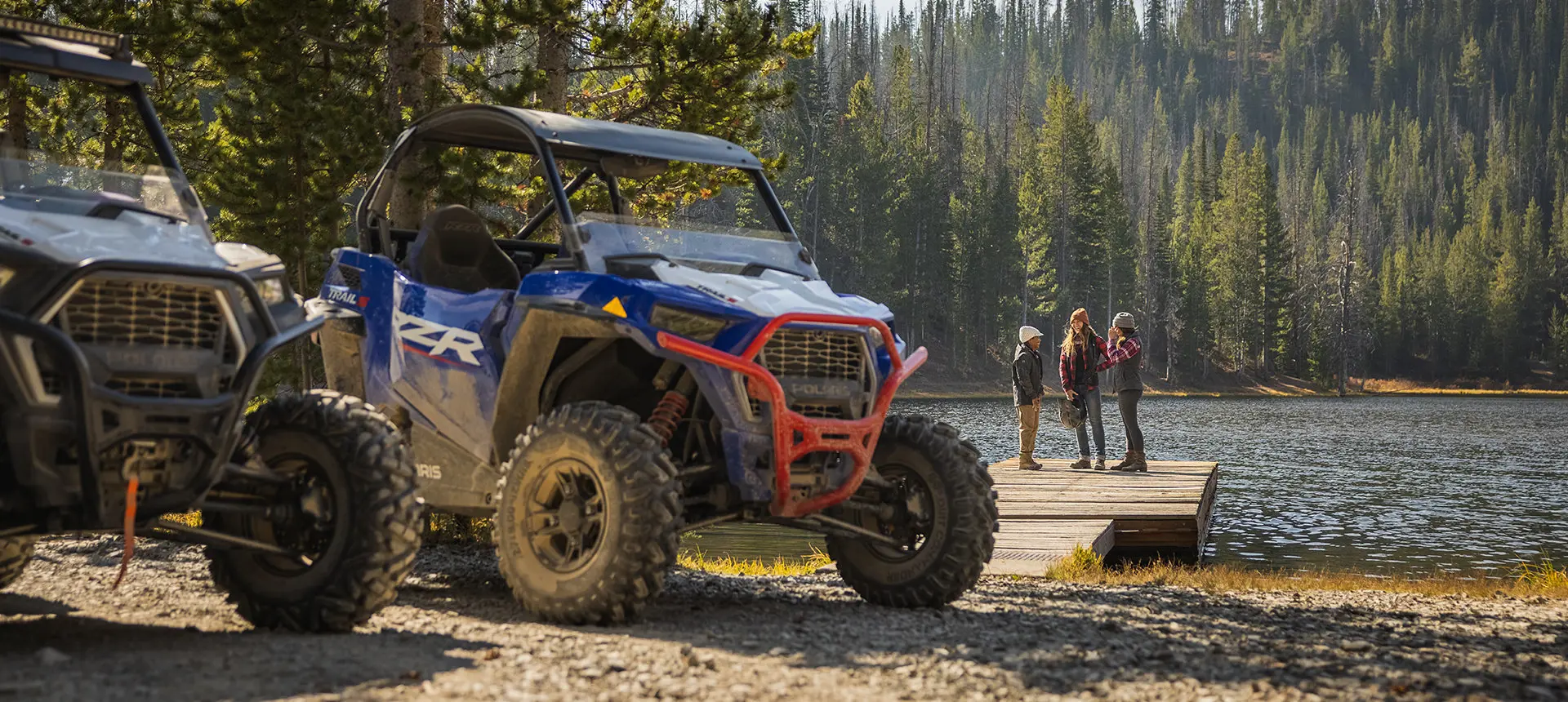 vue avant de deux RZR stationnés devant un lac