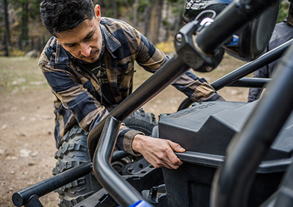 Hombre usando las opciones de almacenamiento flexibles en su RZR Trail