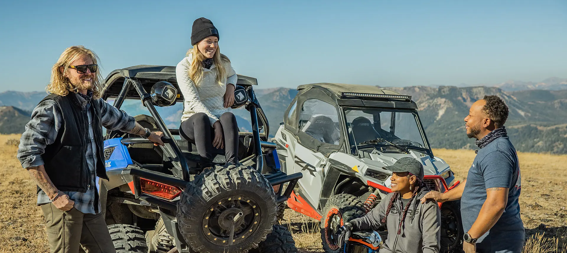 un groupe d’amis bavardAnt près de leur RZR, l’une des filles assises sur le coffre de son rzr