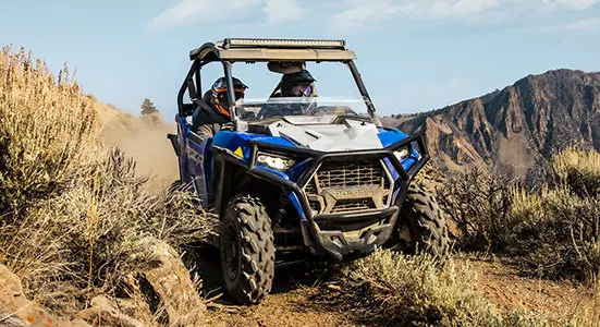un rzr trail sport traversant un sentier de montagne