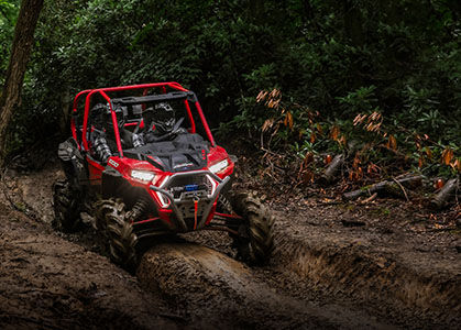 RZR XP 1000 High Lifter and drivers going through an extreme mud trail.