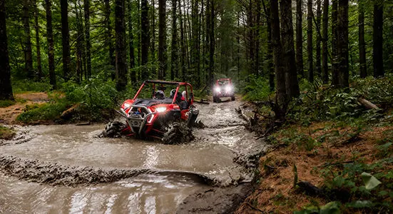 RZR XP 1000 High Lifter powering through a mud hole