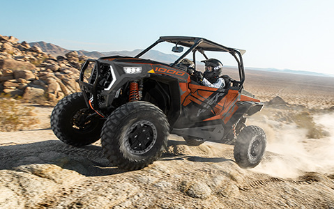 Vue latérale d’un RZR XP trails and rocks qui traverse un sentier du désert
