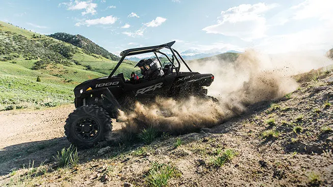 riders in a black rzr xp 1000 descending a treacherous hill