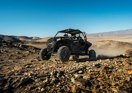 4 riders in a rzr xp 4 1000 off-roading through some rocky terrain with unmatched traction