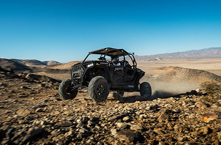 2 riders in a polaris rzr xp 4 1000 off-roading