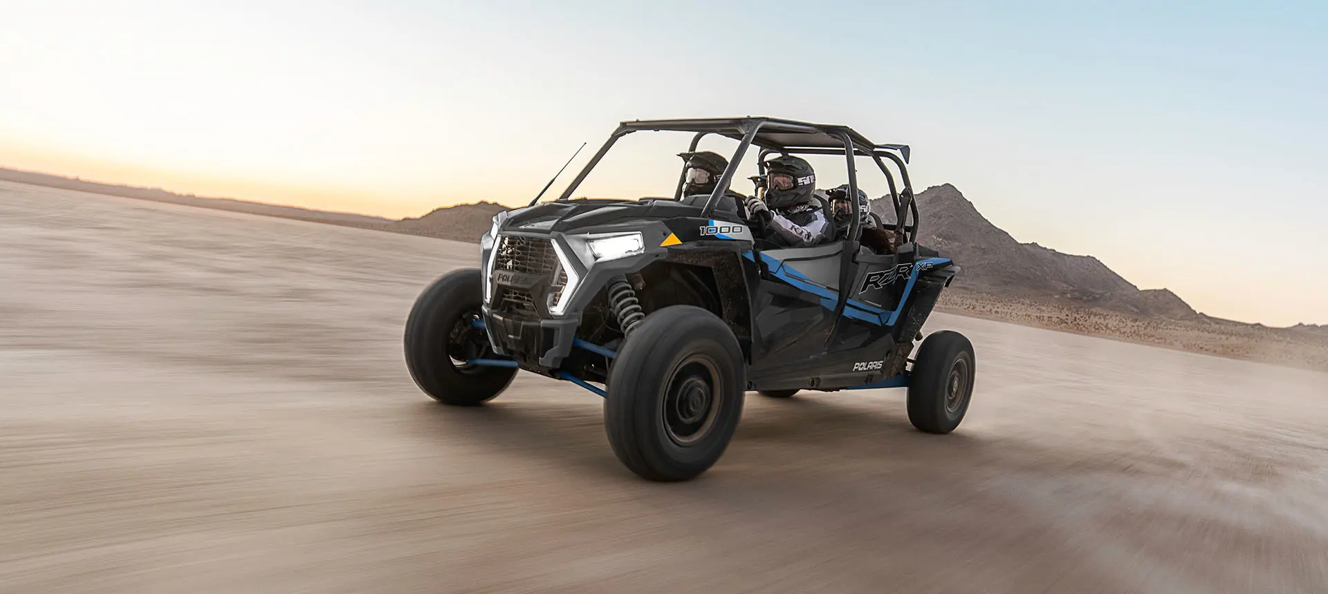 4 riders in a rzr xp 4 1000 speeding through the desert