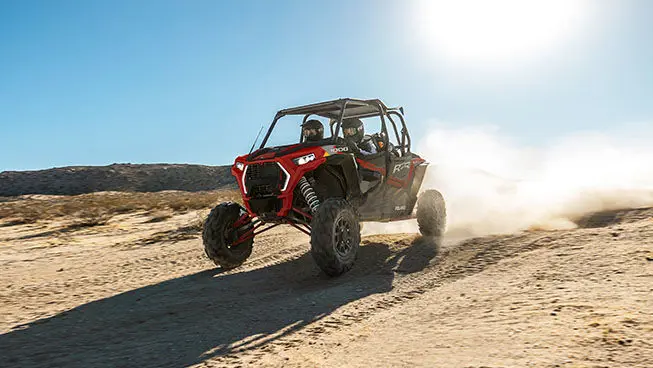 4 riders in a rzr xp 4 1000 speeding through the dunes