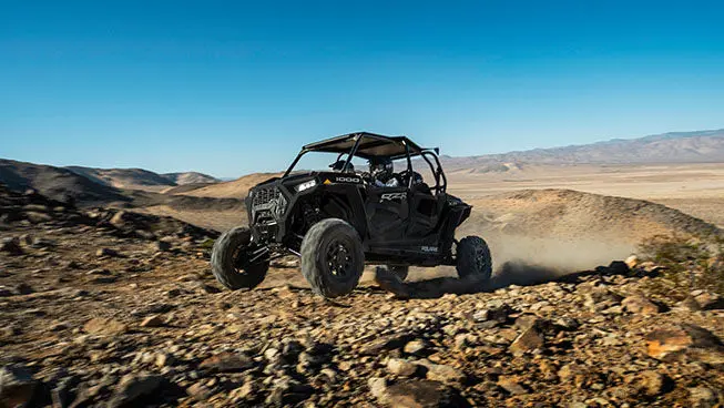 4 riders in a rzr xp 4 1000 off-roading through some rocky terrain