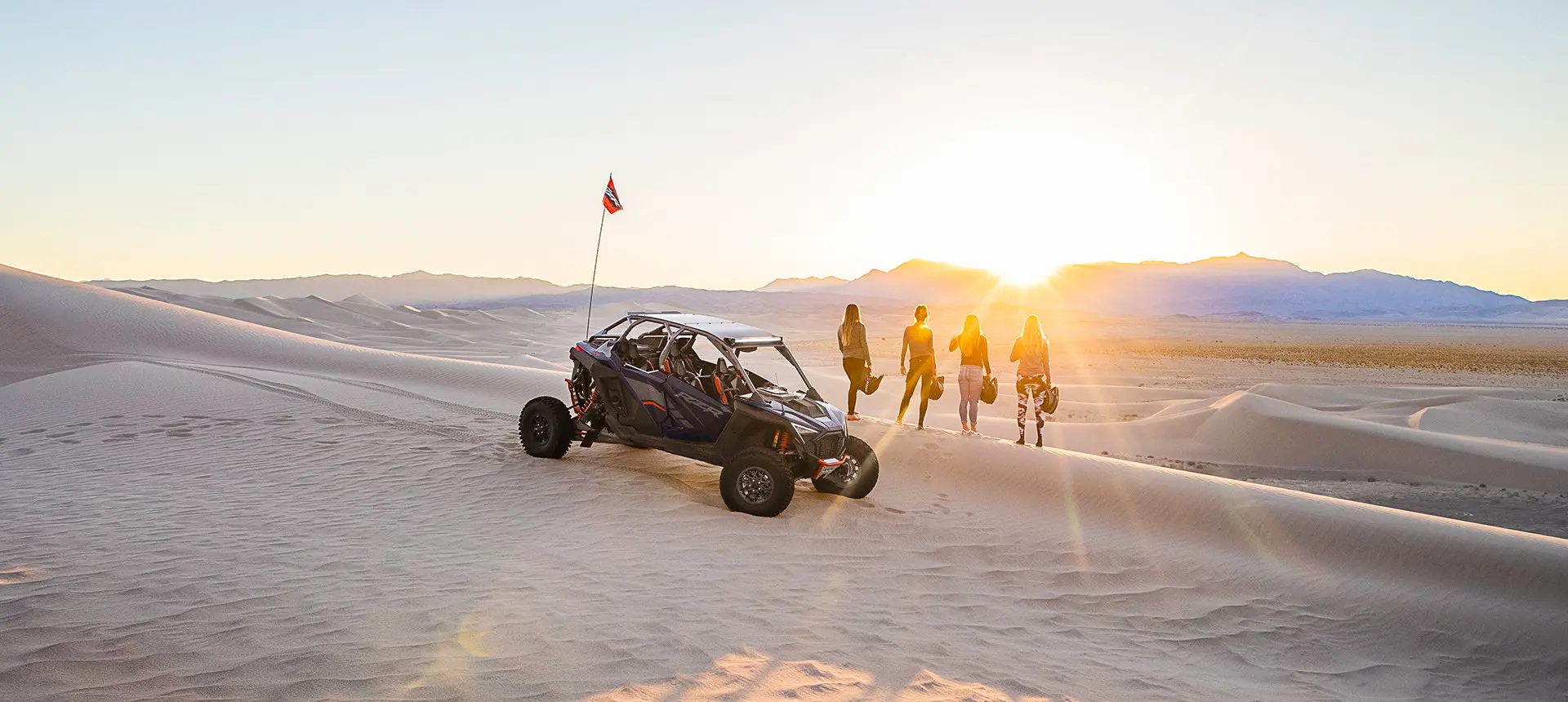 personas mirando fijamente al atardecer cerca de su polaris rzr pro r 4 side by side