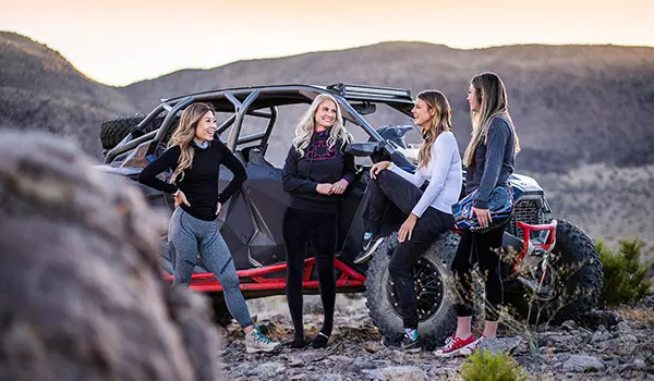un grupo de mujeres relajándose después de un paseo en su polaris rzr pro r 4 side by side