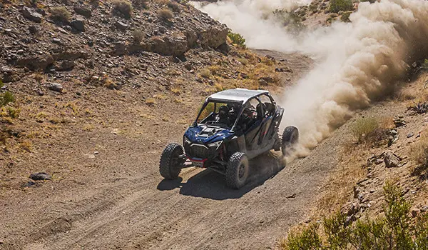 un polaris rzr pro r 4 side by side paseando por un sendero del desierto