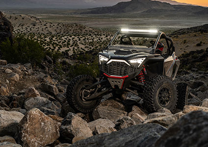 un polaris rzr pro r con faros delanteros y barra de luces encendidos