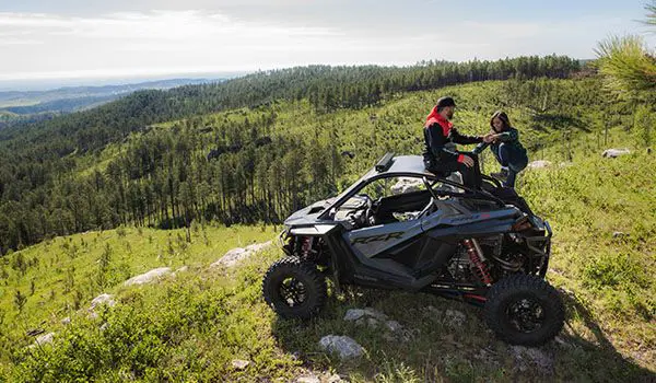una pareja relajándose después de un paseo en su polaris rzr pro r
