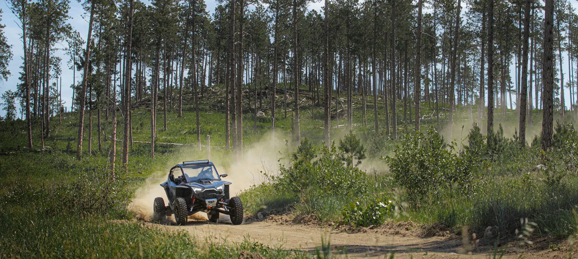 un polaris rzr pro r recorriendo un sendero forestal