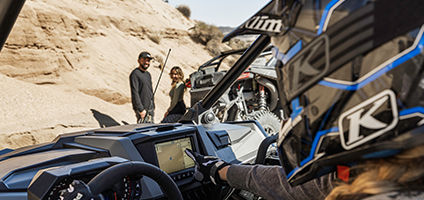driver pointing to the ride command powered touchscreen in their polaris rzr turbo r 4 side by side
