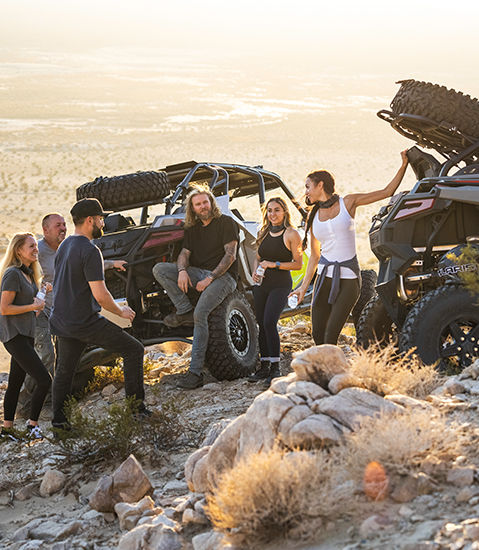 people relaxing around their polaris rzr turbo r 4 side by sides