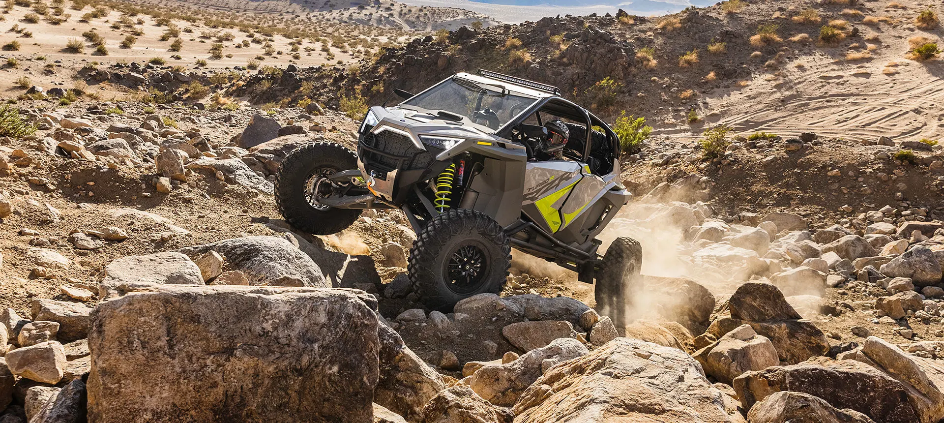 polaris rzr turbo r 4 side by side climbing over rocky terrain