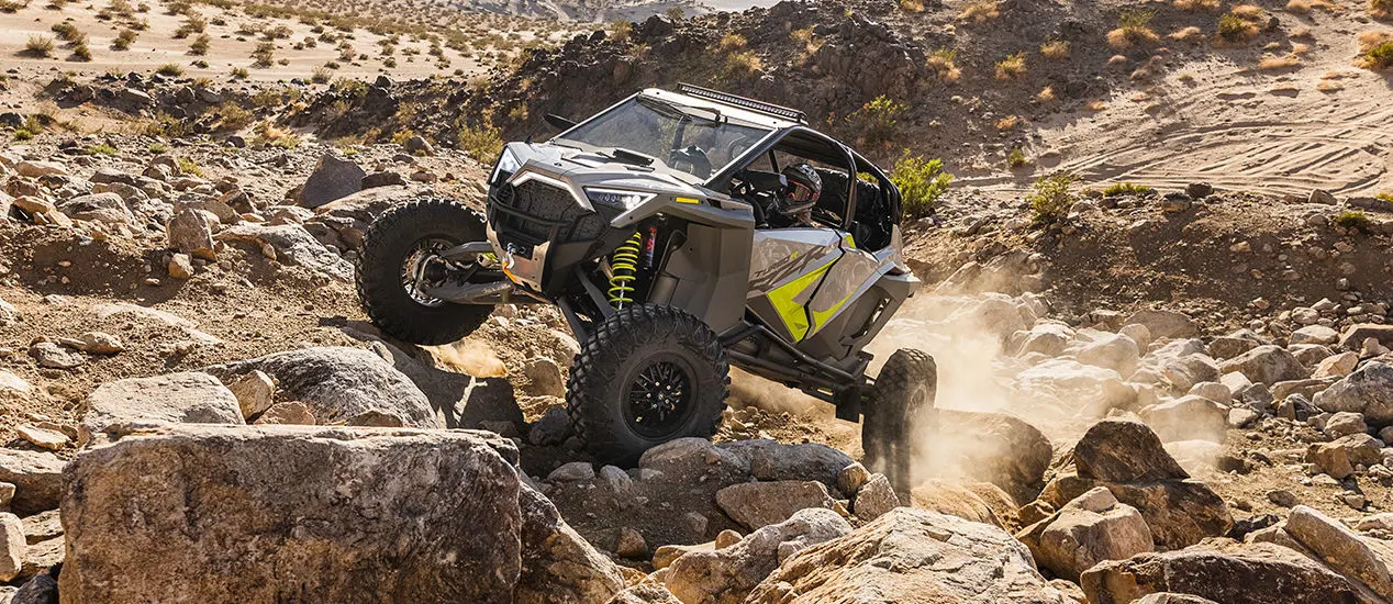 polaris rzr turbo r 4 side by side climbing over rocky terrain