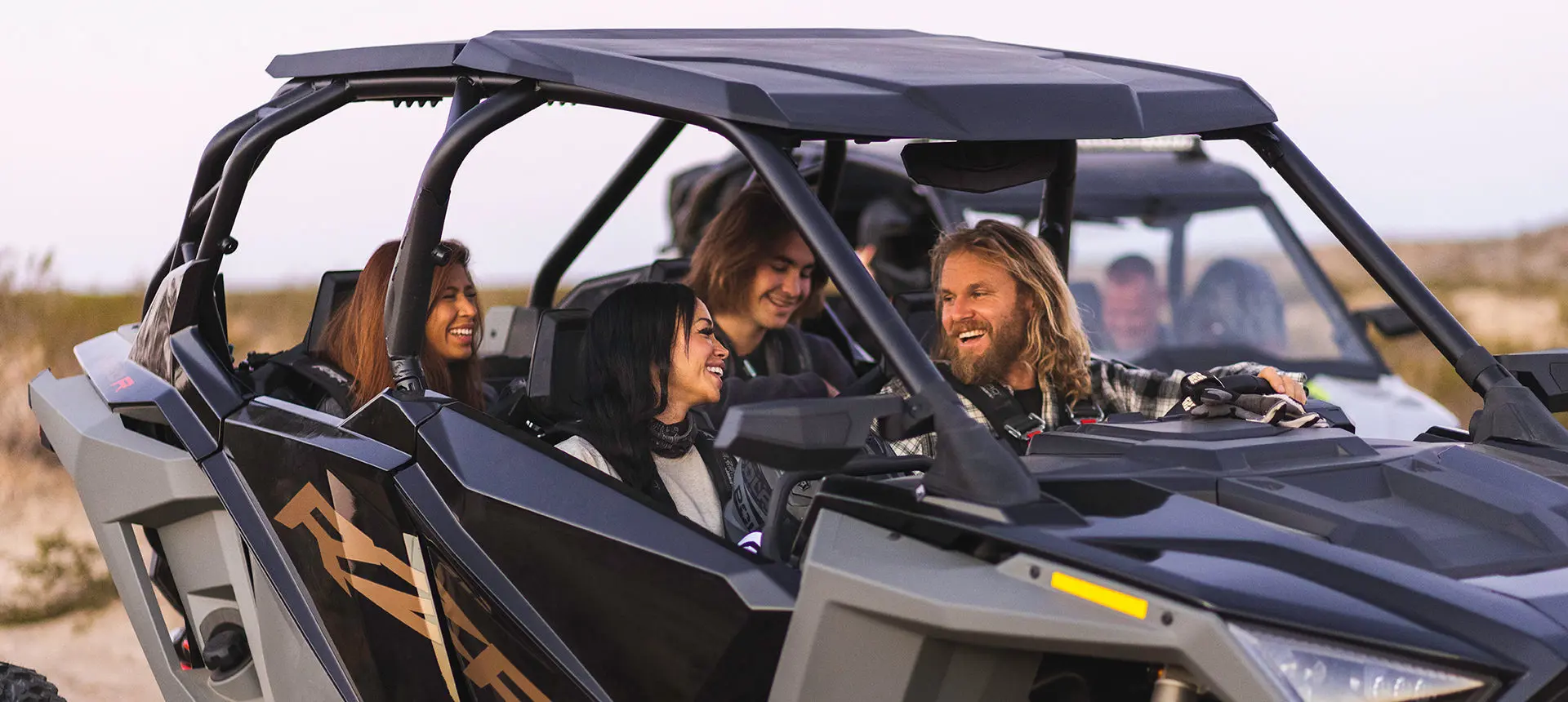 riders having a good time in a polaris rzr turbo r 4 side by side