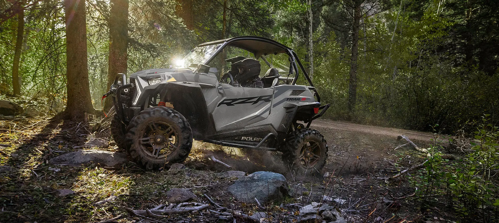 side profile of a rzr trail side by side climbing rocky terrain