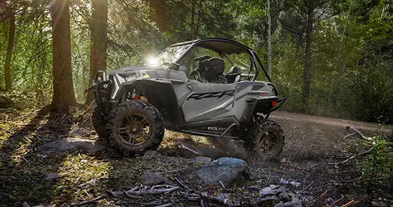 side profile of a rzr trail side by side climbing rocky terrain