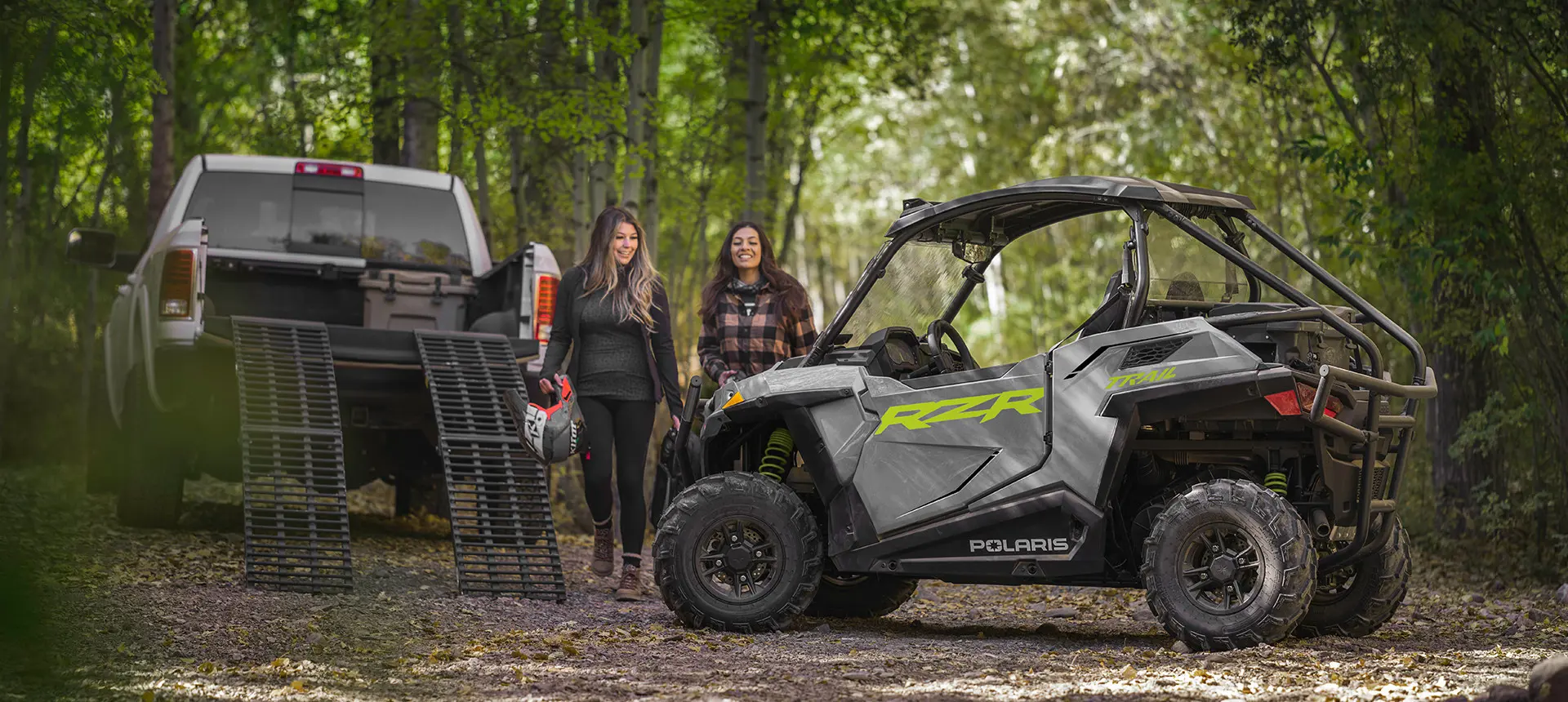 couple of women unloading a blue rzr trail side by side