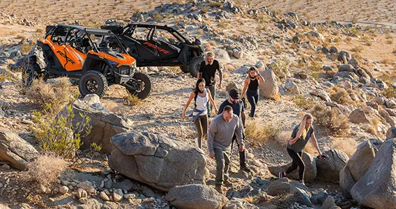 amis regardant le paysage après un tour dans leur côte à côte rzr à ciel ouvert