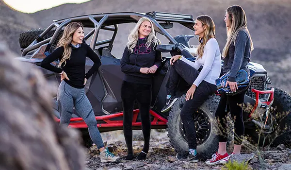 group of women relaxing after a ride in their rzr pro r 4 side by sides