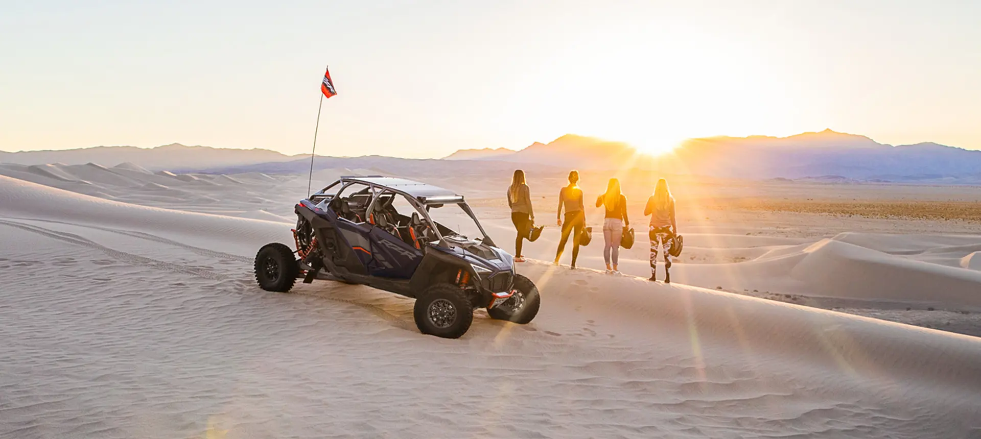 people staring into the sunset near their rzr pro r 4 side by side
