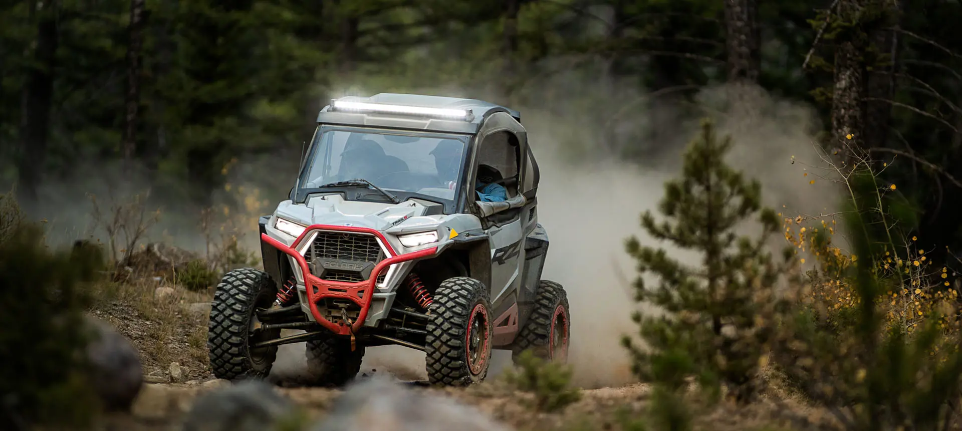 RZR Trail side by side cruising on a forest trail